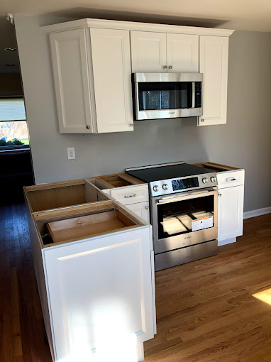 A kitchen with white cabinets and a silver oven