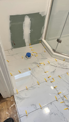 A bathroom that is being remodeled with yellow tape on the floor